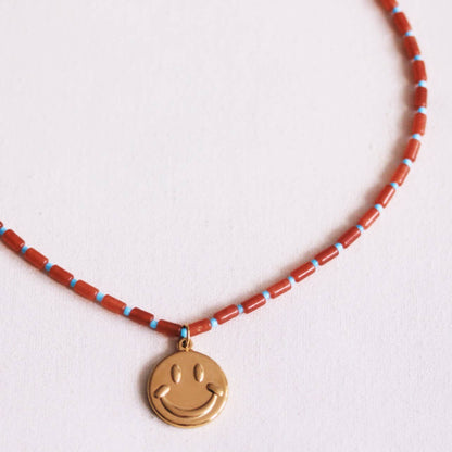 Beaded necklace of tubes with smiley - rust/light blue