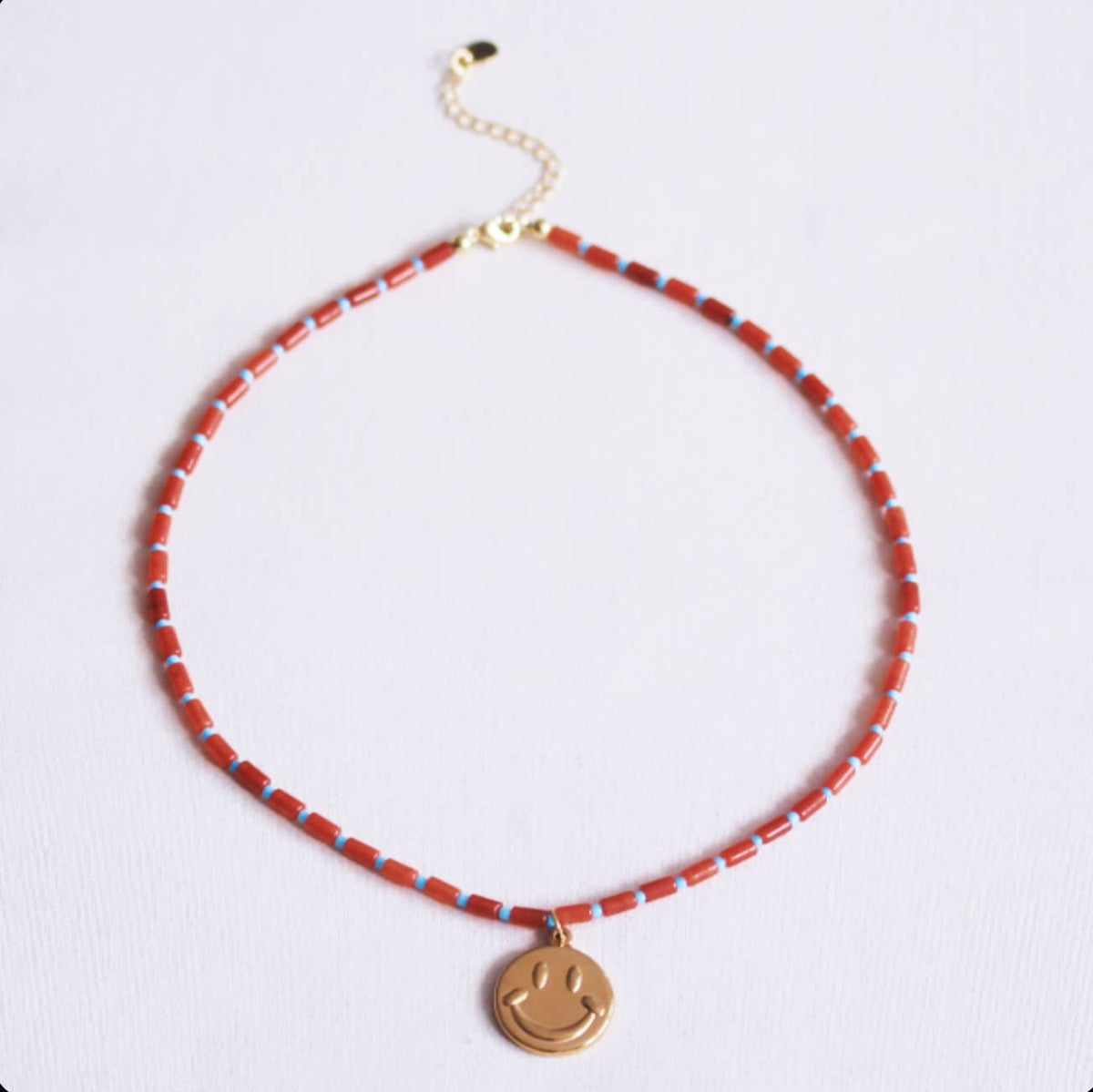 Beaded necklace of tubes with smiley - rust/light blue